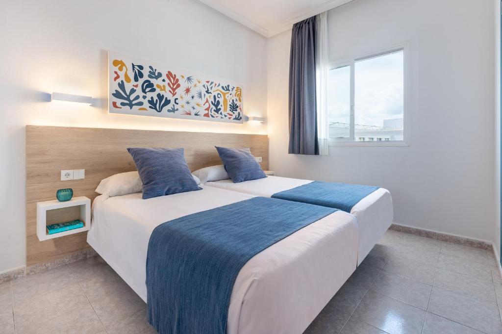 伊维萨镇Hotel Apartamentos Vibra Lux Mar的一间卧室设有一张大床和一个窗户。