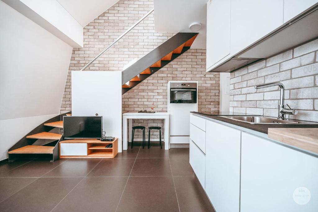 阿尔泽特河畔埃施WakeUp Esch-City的厨房配有白色橱柜、水槽和楼梯。