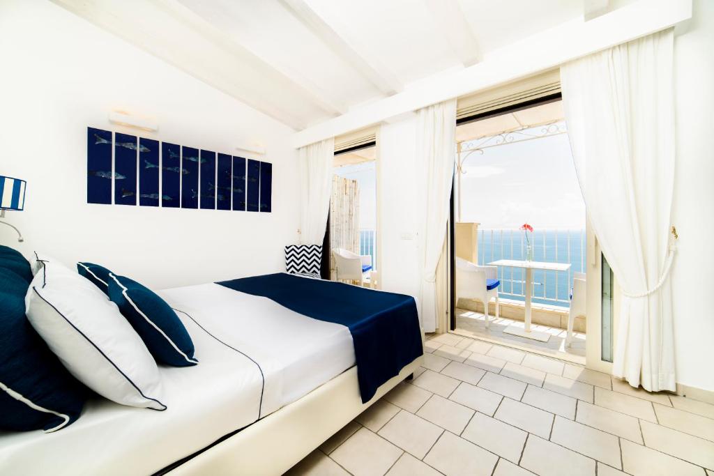 阿马尔菲Residenza Al Pesce D'Oro的白色的卧室设有床和大窗户