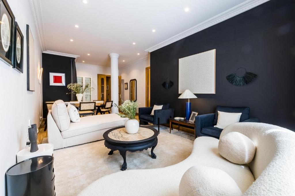圣塞瓦斯蒂安ONDARRA Suite Apartment的客厅设有黑色墙壁和白色家具。