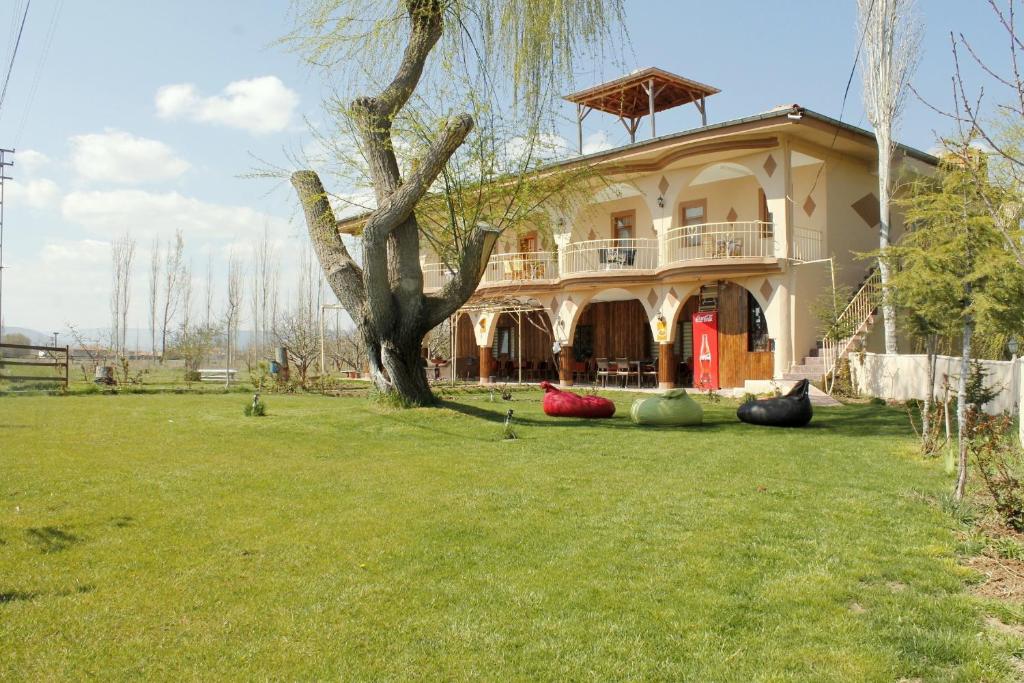 Ovaciftlik苏丹潘神尼天堂鸟酒店的院子中一棵树的大房子
