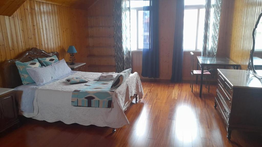 蓬特亚雷亚斯Corazón de Ponteareas的一间卧室配有一张床,铺有木地板