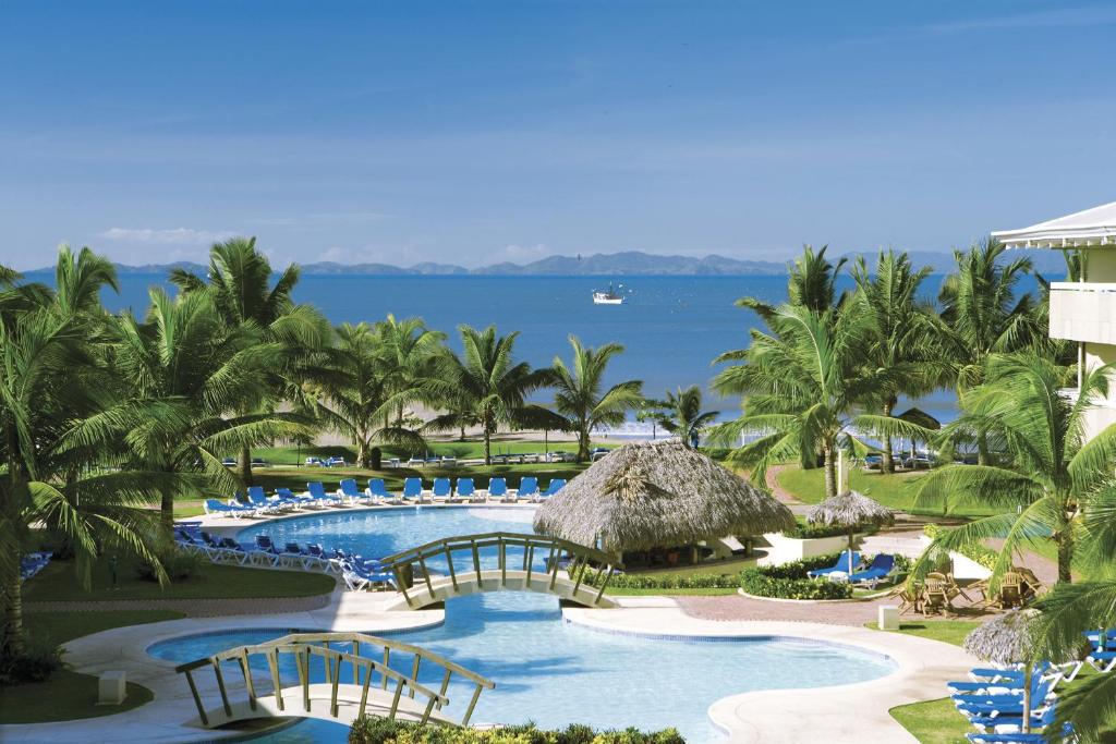 El RobleFiesta Resort All Inclusive Central Pacific - Costa Rica的享有带游泳池和棕榈树的度假村的景致