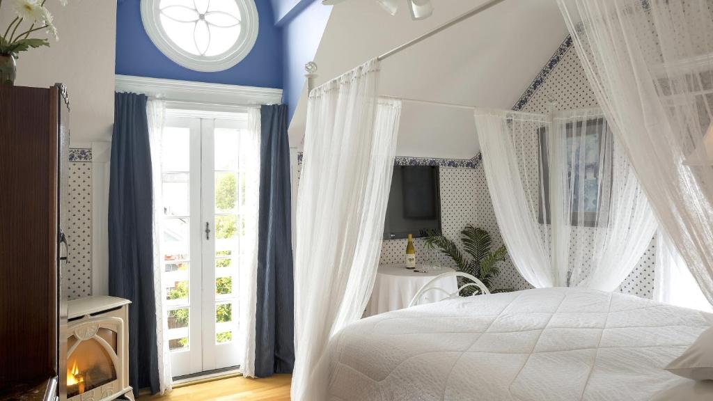 纳帕解百纳之家旧世界住宿加早餐旅馆的卧室配有白色的床、窗帘和窗户