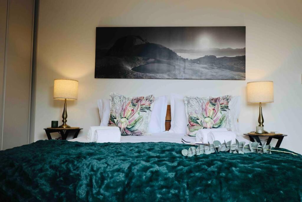 帕尔The Paarl Grand的一间卧室配有一张带两盏灯的大型绿床。