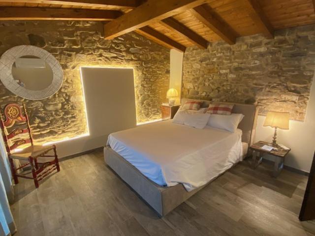 多尔切阿夸Gli Orti dei Doria di dolceacqua的一间卧室设有一张床和石墙