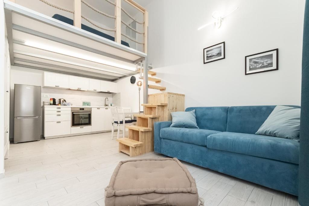 热那亚Sea Loft Quinto - A due passi dal mare的一间带蓝色沙发的客厅和一间厨房