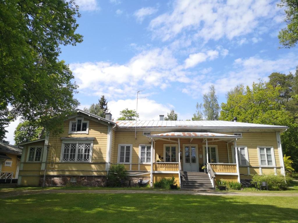 罗威萨Willa Björksten的黄色房子,设有门廊和草坪