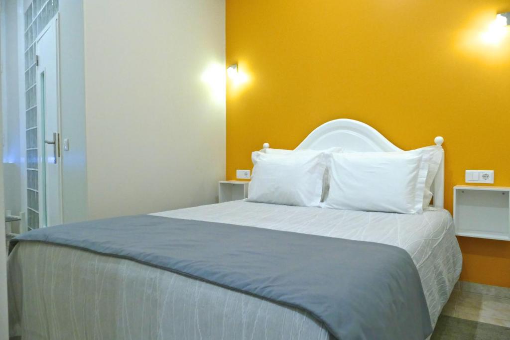 法鲁圣菲利普旅馆的一间卧室设有一张黄色墙壁的大床