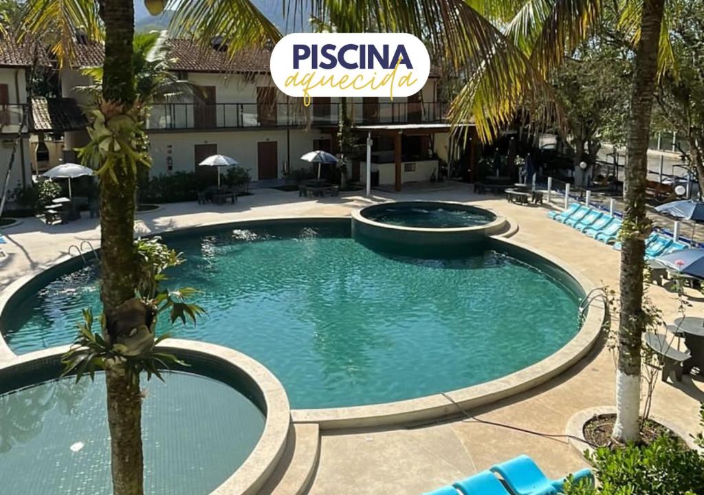 乌巴图巴Pousada Ilha Vitoria的棕榈树度假村内的游泳池