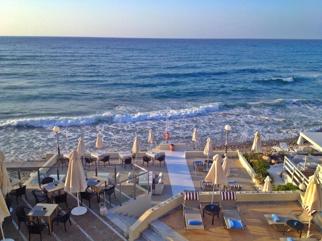 罗希姆诺菲罗夏聂海滩酒店的享有海滩美景,配有椅子和遮阳伞
