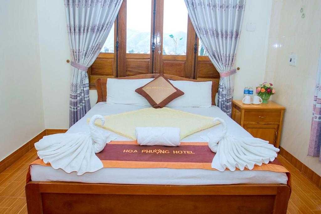 峰牙HOA PHUONG PHONG NHA Hotel的一间卧室配有一张大床和木制床头板