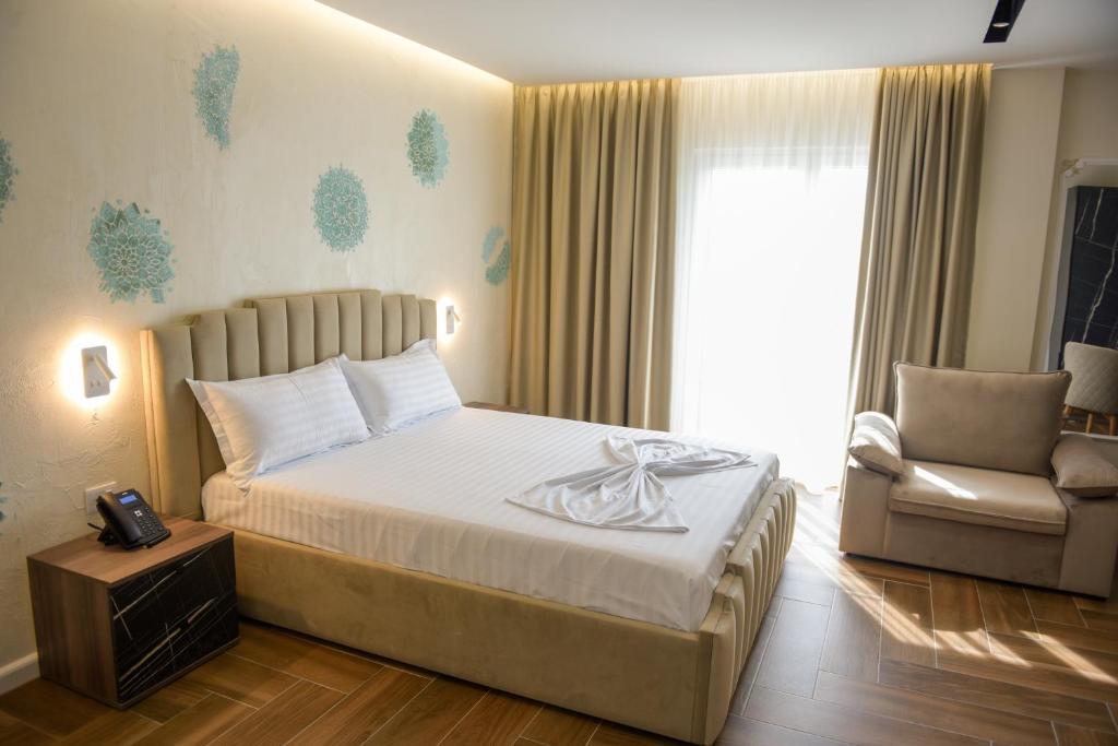 斯库台Hotel Royal的卧室配有床、椅子和窗户。