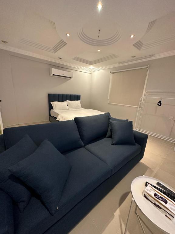 利雅德Villa Apartments的客厅配有蓝色的沙发和床。