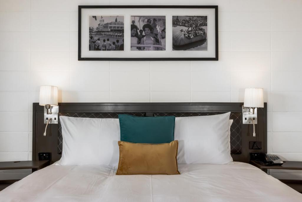 苏瓦Capricorn Hotel Suva的一间卧室配有白色的床和两盏灯
