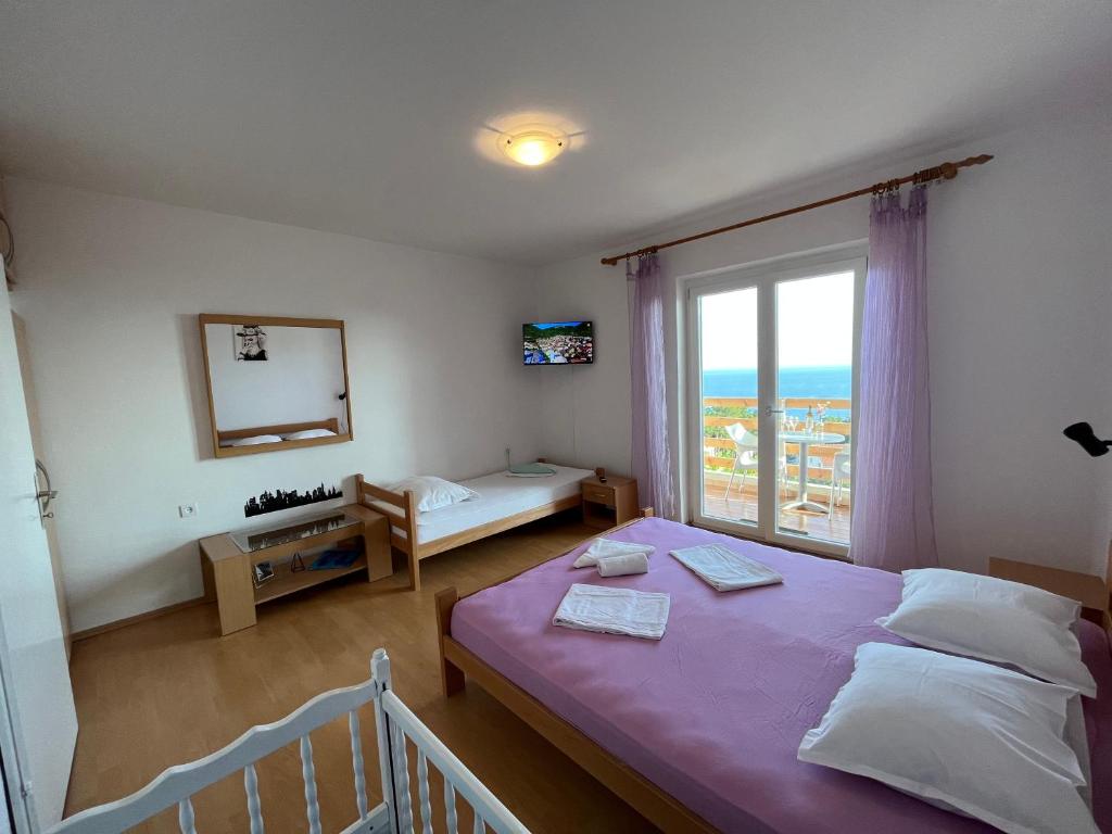 伊万多拉克Apartmani "Nikola" Seaview - Ivan Dolac, Hvar的一间卧室设有一张床和一个大窗户
