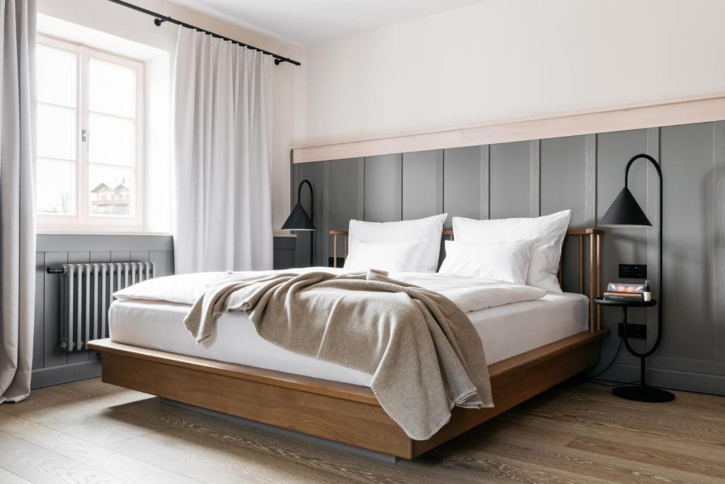 滨湖伦茨Refugium Lunz的一间卧室配有一张大床和灰色床头板