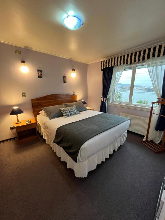 瓦尔迪维亚Montepiedra Costanera Valdivia的一间卧室设有一张大床和一个大窗户