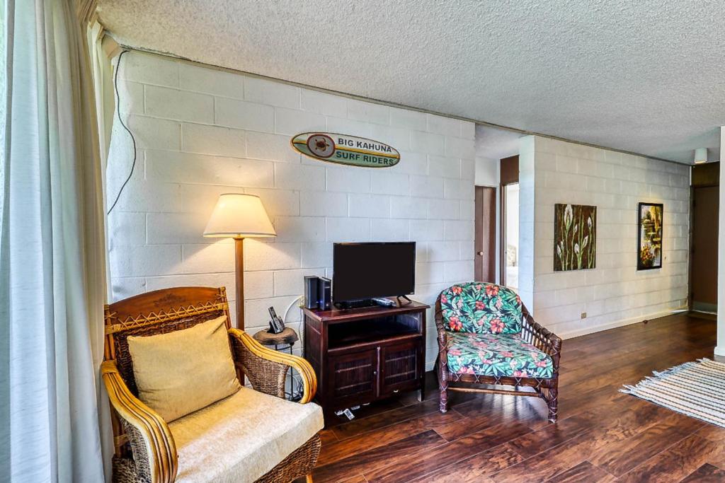 希洛Maunaloa Shores 612的客厅配有沙发、电视和椅子