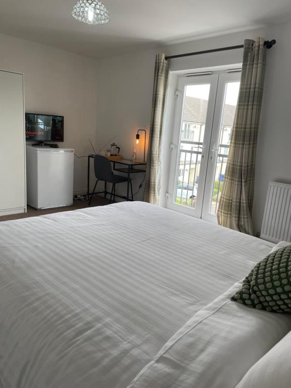 格雷斯瑟罗克Luxury Rooms In Furnished Guests-Only House Free WiFi West Thurrock的卧室配有一张大白色床和窗户