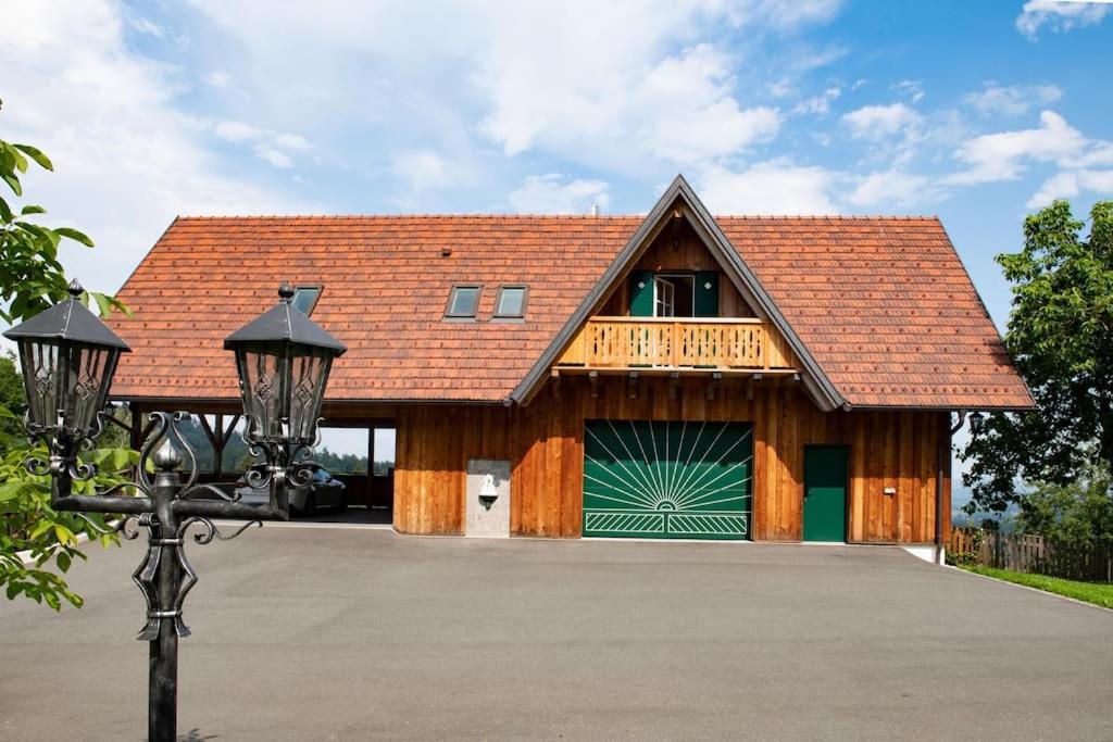 SchwanbergChalet-Südsteiermark - traumhafte Aussicht, Infinity Pool, Privatsphäre, Klima und de-luxe Ausstattung的一个带绿色车库门的车库