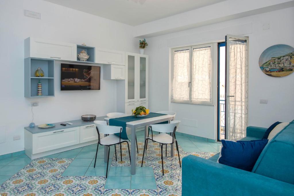 米诺利Casa Sammarco的客厅配有蓝色的沙发、桌子和椅子