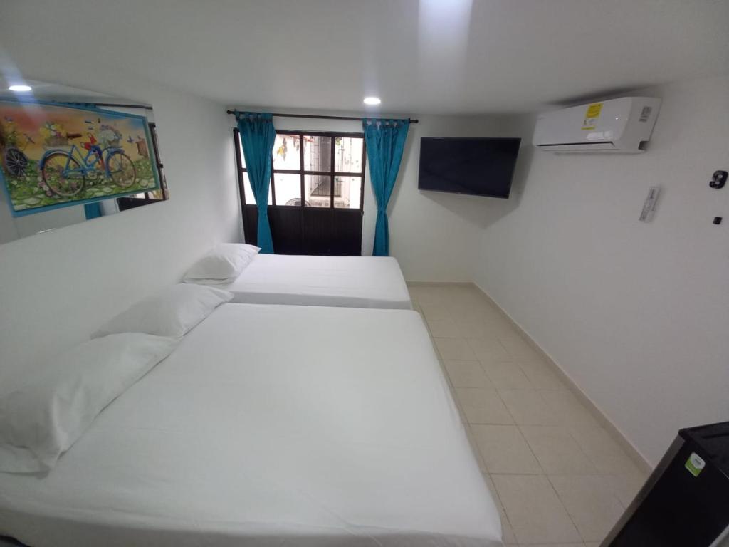 卡塔赫纳Hostal Doña Betty的一间卧室设有两张床和窗户。