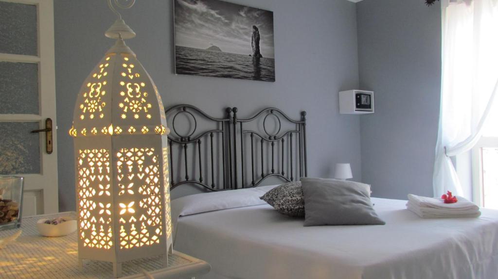 利帕里卡坡洛住宿加早餐酒店的卧室配有白色的床,上面有照明物品