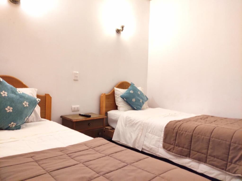 安托法加斯塔Hostal valle de la luna的一间客房配有两张床,一个床头柜配有两张床