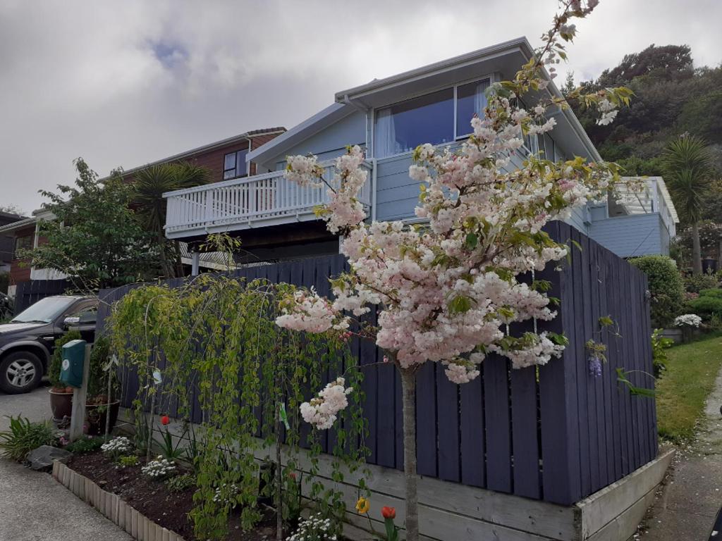 波里鲁阿New, Cosy & Private 1-Bedroom & Living Flat的围栏前有花树的房子