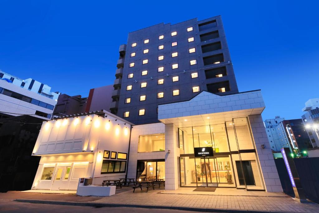 札幌QuintessaHotel SapporoSusukino63 Relax&Spa的前面有桌子的大建筑