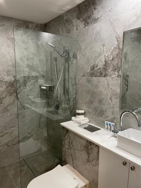 悉尼The Social Hotel, Sydney的带淋浴、卫生间和盥洗盆的浴室