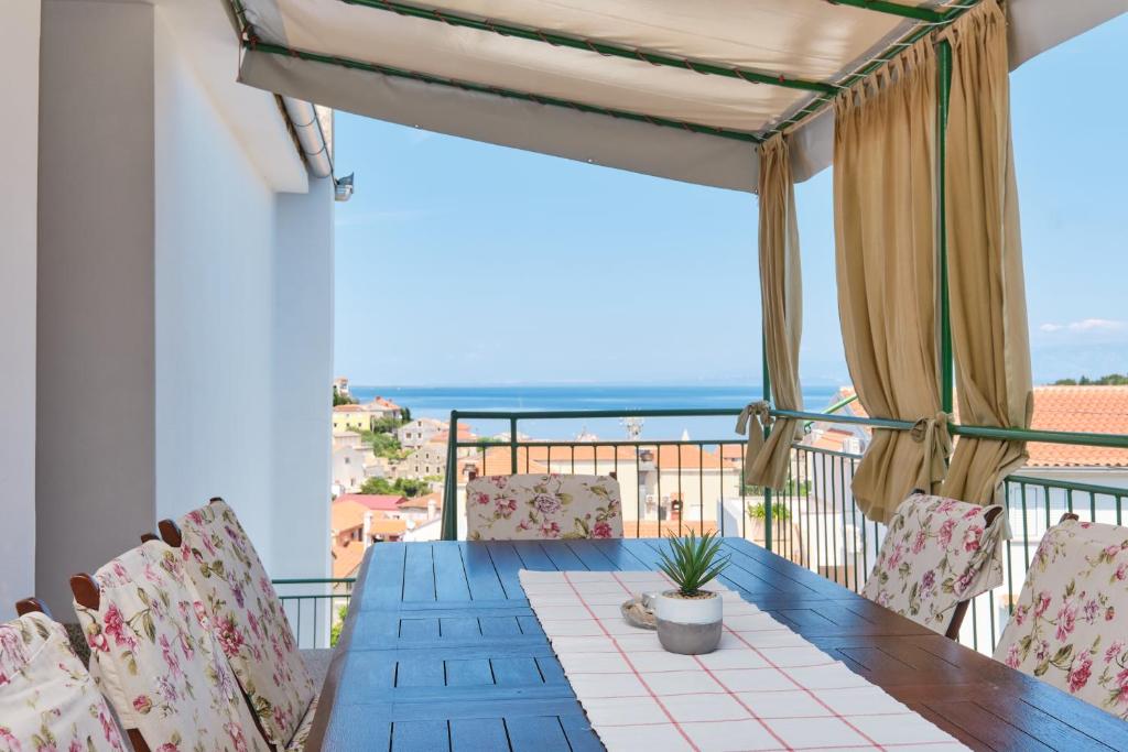 木洛希尼Sea View Apartment Sandra in Mali Lošinj的海景阳台上的桌椅