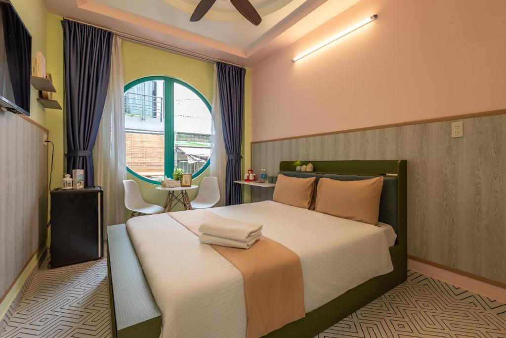 胡志明市Cô Châu Homestay的一间卧室设有一张大床和一个窗户。