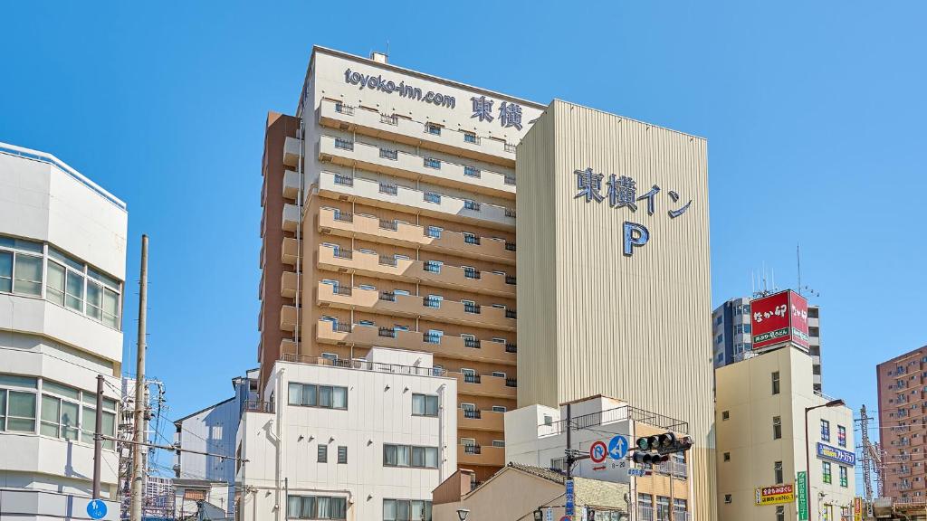 大阪Toyoko Inn Osaka JR Noda Ekimae的城市中带有标志的建筑