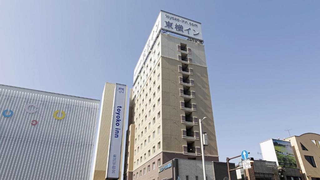 宇都宫Toyoko Inn Tobu Utsunomiya eki Nishi guchi的一座高大的建筑,旁边有一个标志