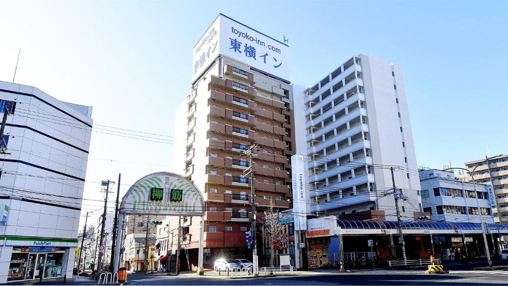 神户Toyoko Inn Kobe Minatogawa Koen的一座高大的建筑,上面有标志