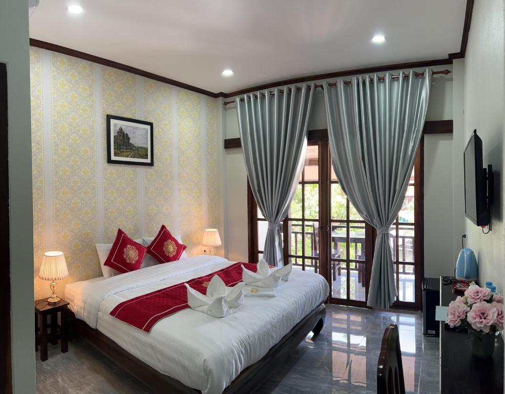 琅勃拉邦Le KhounSok Boutique Hotel的一间卧室设有一张床和一个大窗户