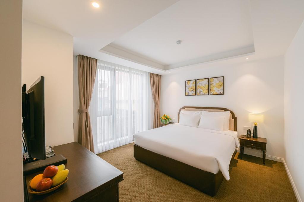 河内Marigold Hotel Hanoi的酒店客房,配有床和电视
