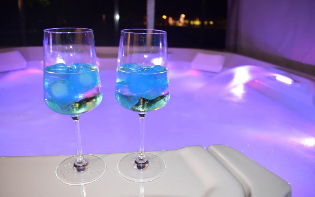 格赫伦-莱宾Luxus_SPA_EG_Fewo AQUAMARIN _WE 1_的浴缸顶部的两杯酒杯