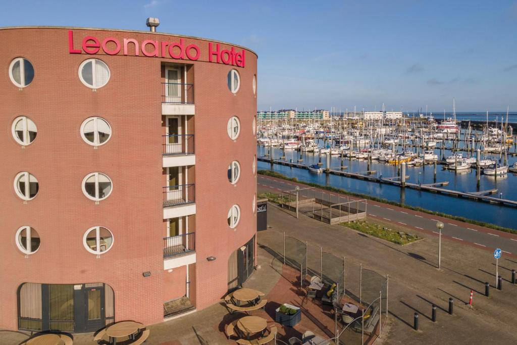 艾默伊登Leonardo Hotel IJmuiden Seaport Beach的水中拥有船坞的酒店