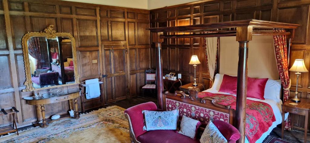 米德尔赫姆Braithwaite Hall Bed & Breakfast的一间卧室配有天蓬床和镜子