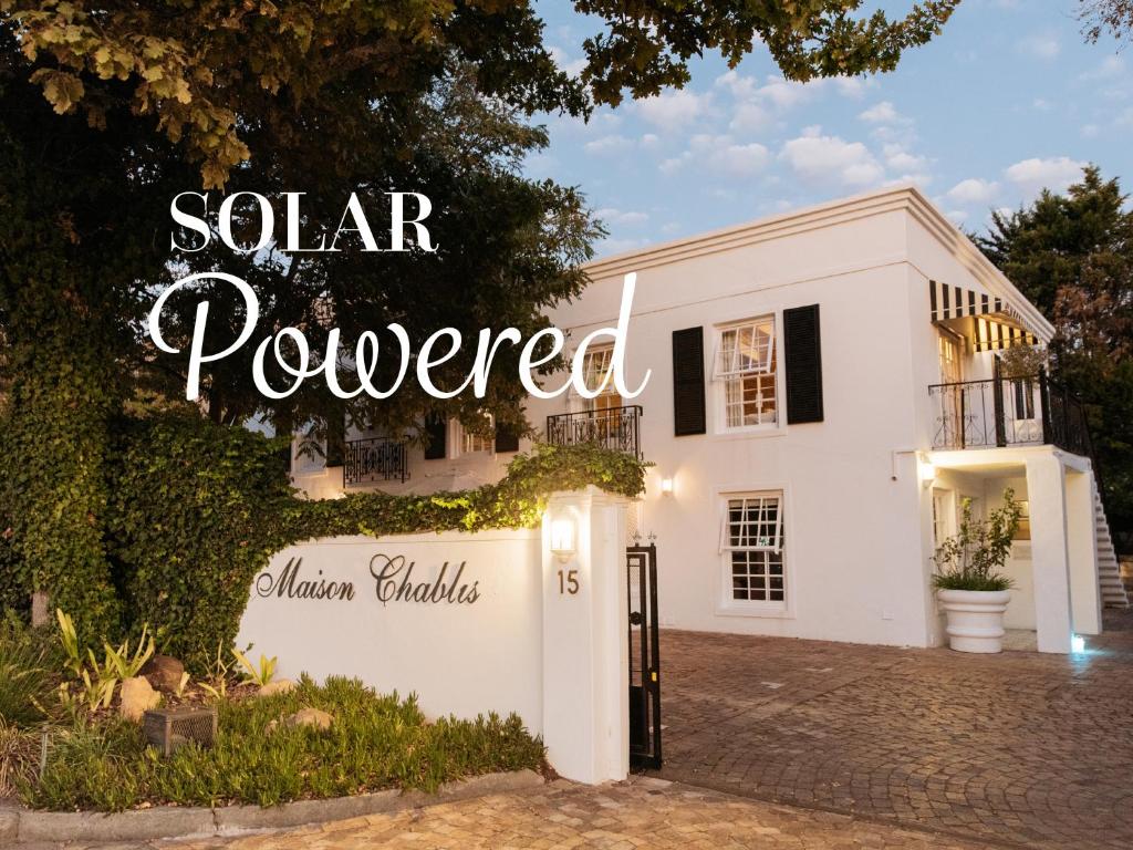 弗朗斯胡克Maison Chablis Guest House的一座白色的房子,上面标有太阳能供电的标志
