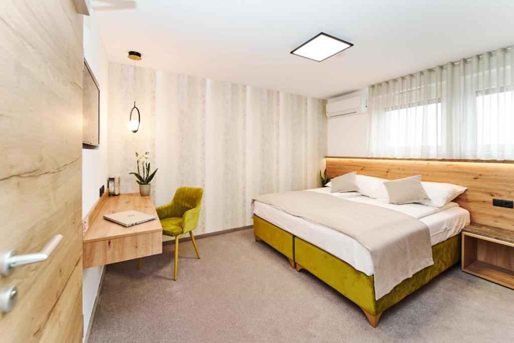 Feldkirchen bei GrazMedirooms Apartments的一间卧室配有一张床、一张桌子和一把椅子