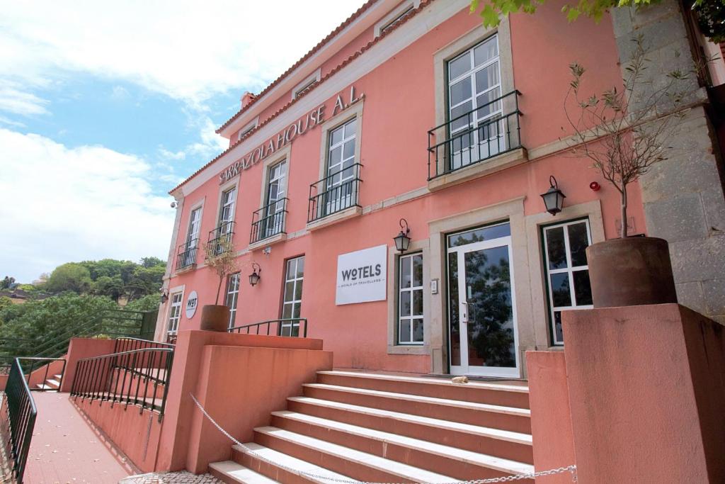 辛特拉WOT Sintra Sarrazola的粉红色的建筑,前面有楼梯