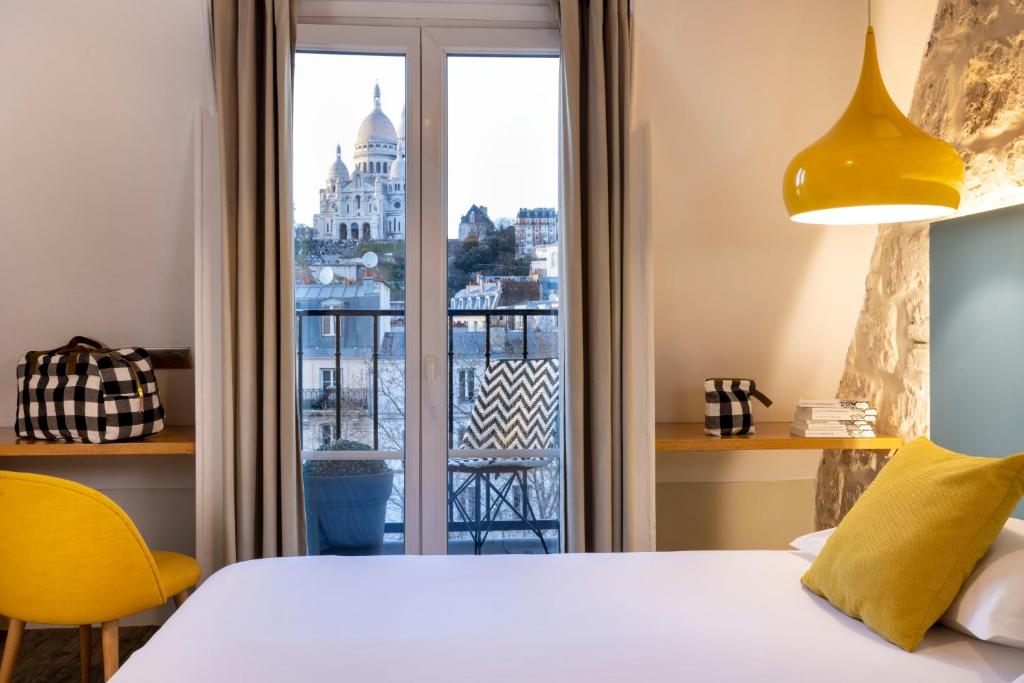 巴黎蒙马特丽晶嘻哈旅舍的一间卧室设有一张床和一个大窗户