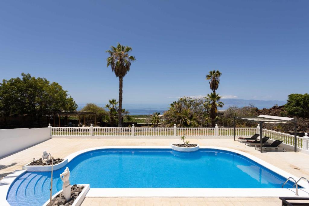阿坎提拉德洛斯基拉斯弗洛雷斯别墅酒店的一个带白色围栏和棕榈树的游泳池