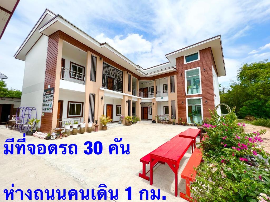 清刊โรงแรมบ้านครูตุ้ม เชียงคาน เลย Baankrutoom Hotel Chiangkhan Loei的前面有红色长椅的房子