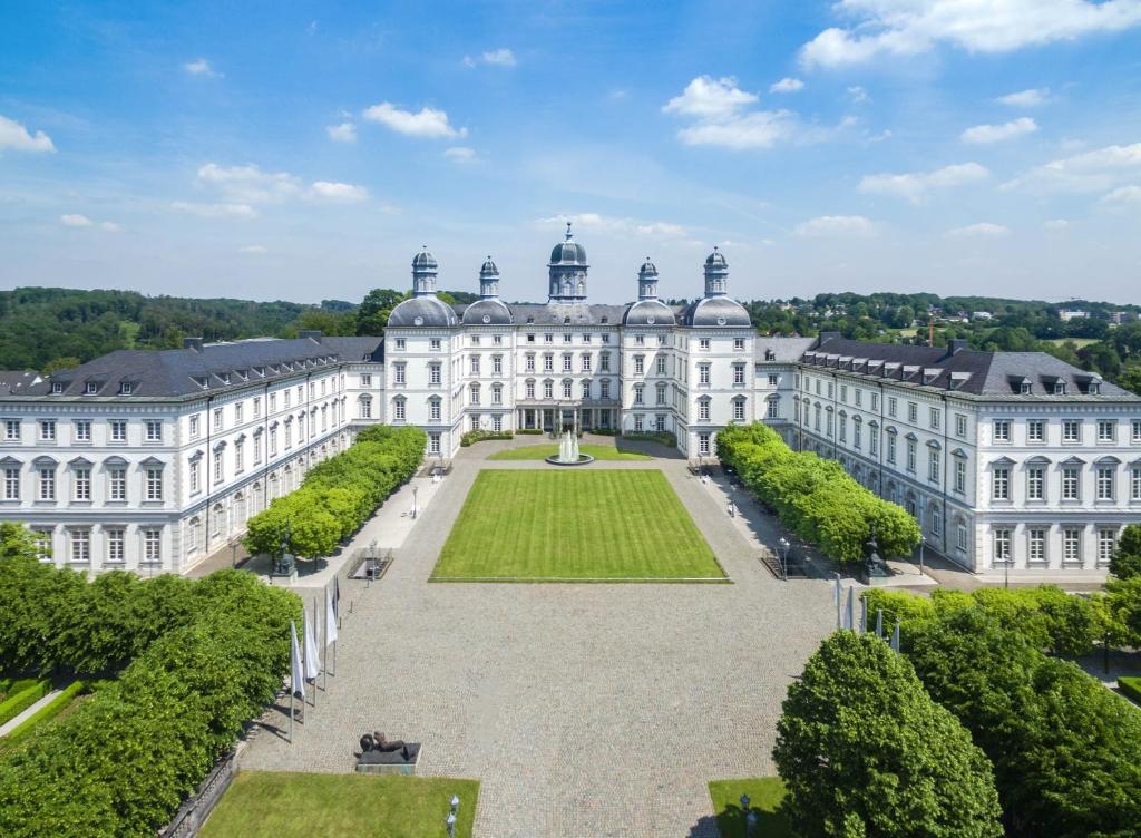 贝尔吉施格拉德巴赫阿尔特霍夫施洛斯本斯堡大酒店的享有大型白色建筑空中美景,设有花园