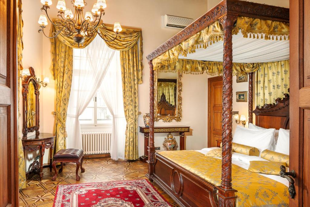 布拉格Hotel U Prince Prague by BHG的一间卧室配有天蓬床和镜子